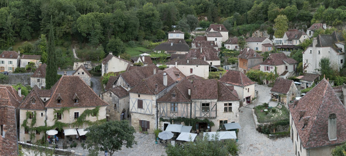 Vecchie case in pietra con tetti di tegole fiancheggiano una strada tortuosa del villaggio.